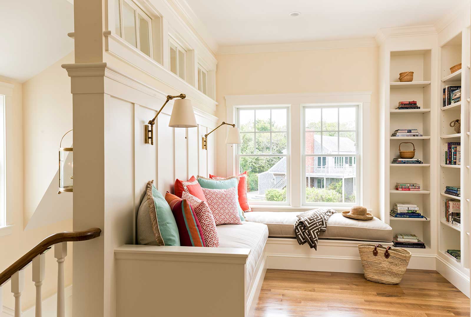 Landing-on-the-Second-Floor-of-a-Cape-Cod-Home-Styled-with-a-Built-In-Sofa-and-Bookcases